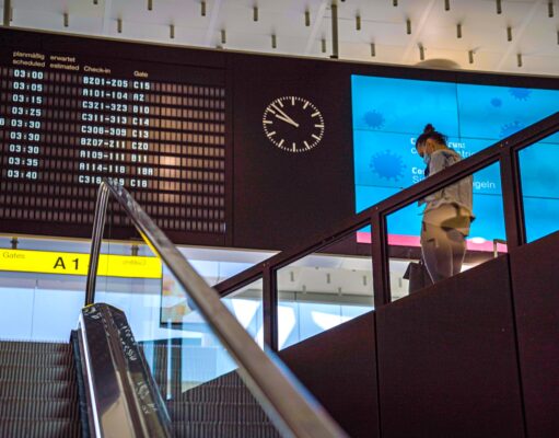EU-Fluggastrechte stärken Passagierrechte EU.Fluggastrechte gesichert: Anzeigetafel auf einem Flughafen, eine Person steigt eine Treppe herab