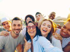 Kundenbindung im Tourismus neu gedacht Kundenbindung im Tourismus neu gedacht: Gruppe junger Männer und Frauen, die lachend den Fotografen anschauen und DAUMEN HOCHHEBEN