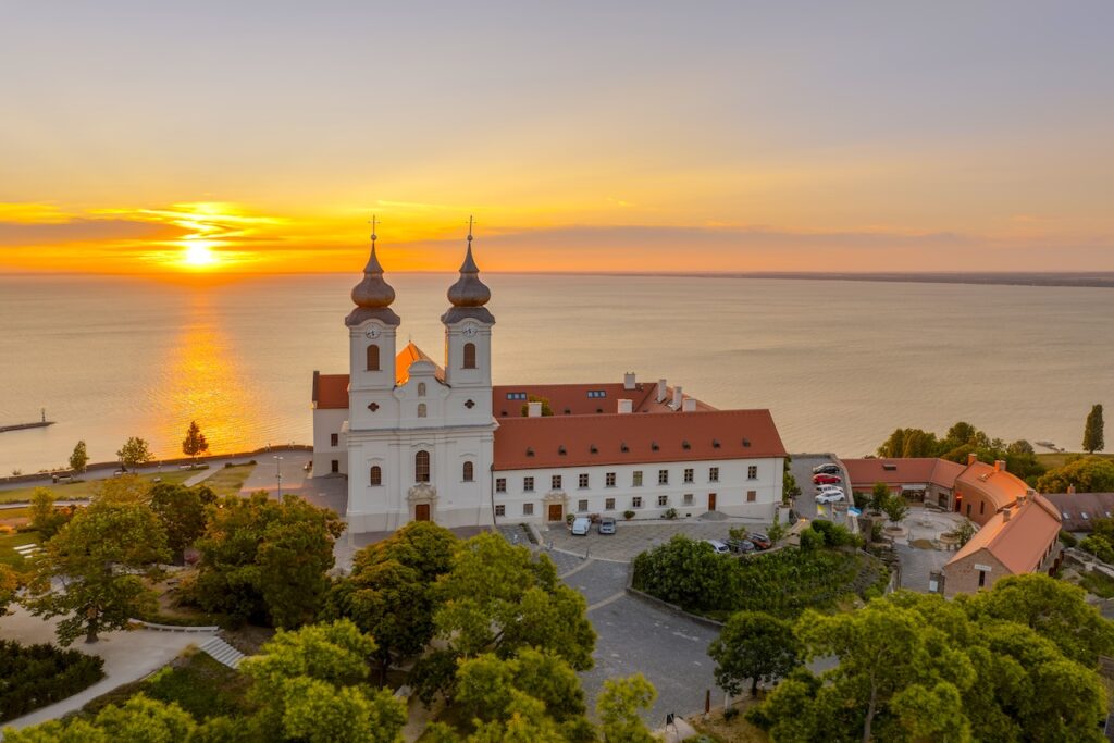 Urlaub mit Hunde am Balaton: Kirche mit Doppelturm am Balaton mit Blick auf den See und Sonnenuntergang