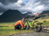 Legendäre Radtouren von Island bis Südkorea Legendäre Radtouren: Radfahrer stellt das Gang bei einem beladenen Fahrrad in der rauen Landschaft Islands unter dramatischen Himmel ein.