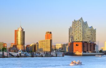 Incoming Tourismus in Deutschland auf Wachstumskurs Incoming Tourismus in Deutschland: Hamburger Hafen bei Sonnenuntergang mit der Elbphilharmonie auf der rechten Seite mit ihrer gläsernen Struktur und ihrem wellenförmigen Design