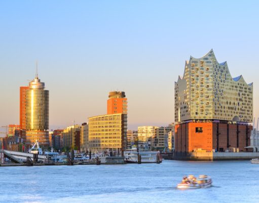 Incoming Tourismus in Deutschland auf Wachstumskurs Incoming Tourismus in Deutschland: Hamburger Hafen bei Sonnenuntergang mit der Elbphilharmonie auf der rechten Seite mit ihrer gläsernen Struktur und ihrem wellenförmigen Design