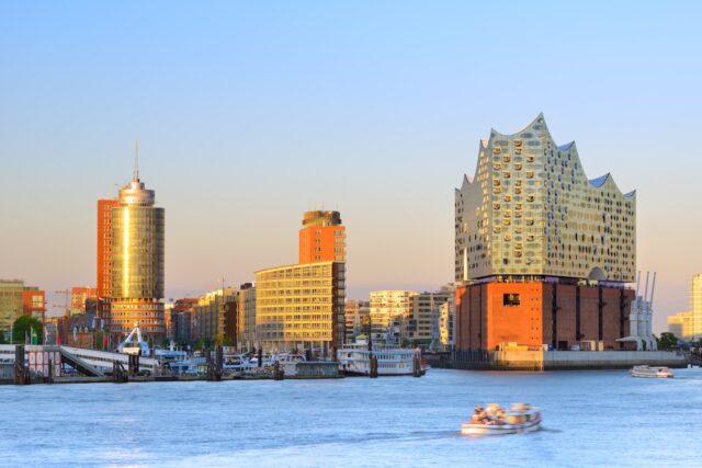 Incoming Tourismus in Deutschland Incoming Tourismus in Deutschland: Hamburger Hafen bei Sonnenuntergang mit der Elbphilharmonie auf der rechten Seite mit ihrer gläsernen Struktur und ihrem wellenförmigen Design