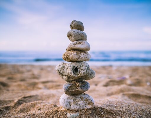 So optimieren Sie Ihre Work-Life-Balance Work-Life-Balance: Mehrere flache Steine sind an einem Strand übereinander gestapelt