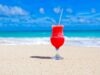 Karibik-Regionalnetz der Air France erweitert Karibik-Regionalnetz der Air France erweitert: Willkommen in Übersee. Auf weißem Sandstrand, im Hintergrund das blaue Meer und der blauen Himmel, steht ein Glas mit pinken Getränk und Strohhalm
