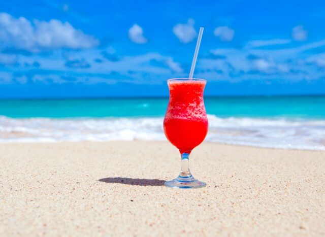 Karibik Regionalnetz Air France Karibik-Regionalnetz der Air France erweitert: Willkommen in Übersee. Auf weißem Sandstrand, im Hintergrund das blaue Meer und der blauen Himmel, steht ein Glas mit pinken Getränk und Strohhalm