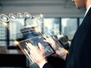 Business Travel: ehotel-CEO über die Zukunft der Geschäftsreise Business Travel der Zukunft: Transparentes Tablet mit Symbolen und Zahlen in der Hand einer Person