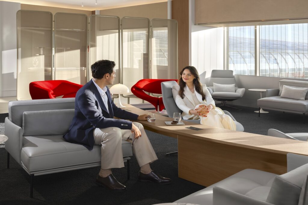 Geschäftsreisen mi9t Air France und KLM: Ein Mann und eine Frau sitzen in einer hellen Lounge mit Glasfenstern und reden miteinander