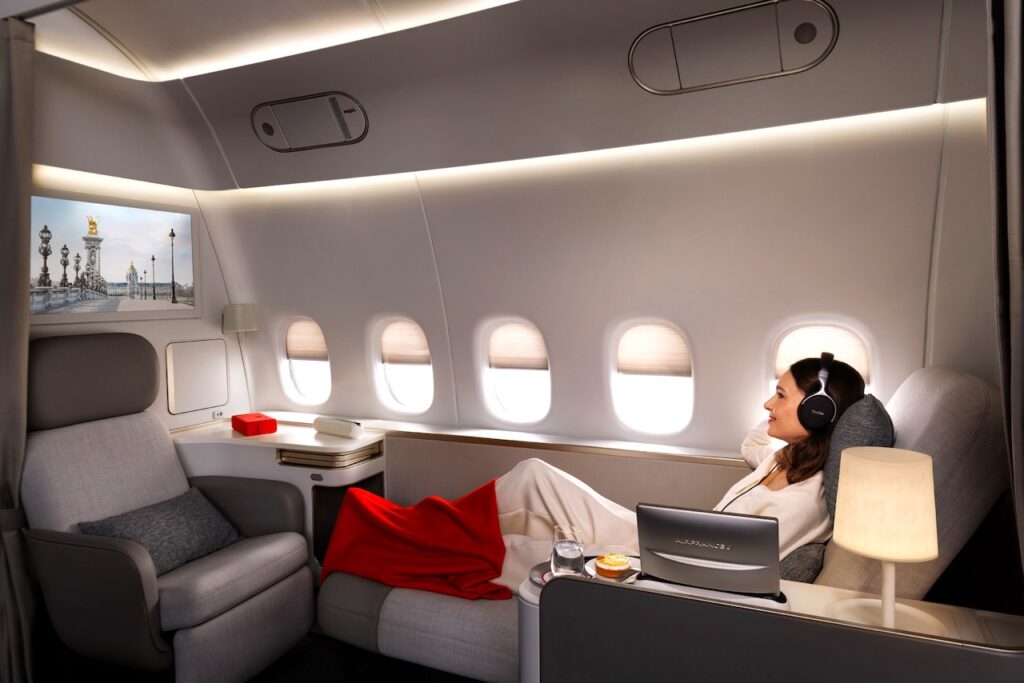 Geschäftsreisen mit Air France und KLM: Eine Frau mit Kopfhörern verfolgt einen Film am Bildschirm in der Suite L