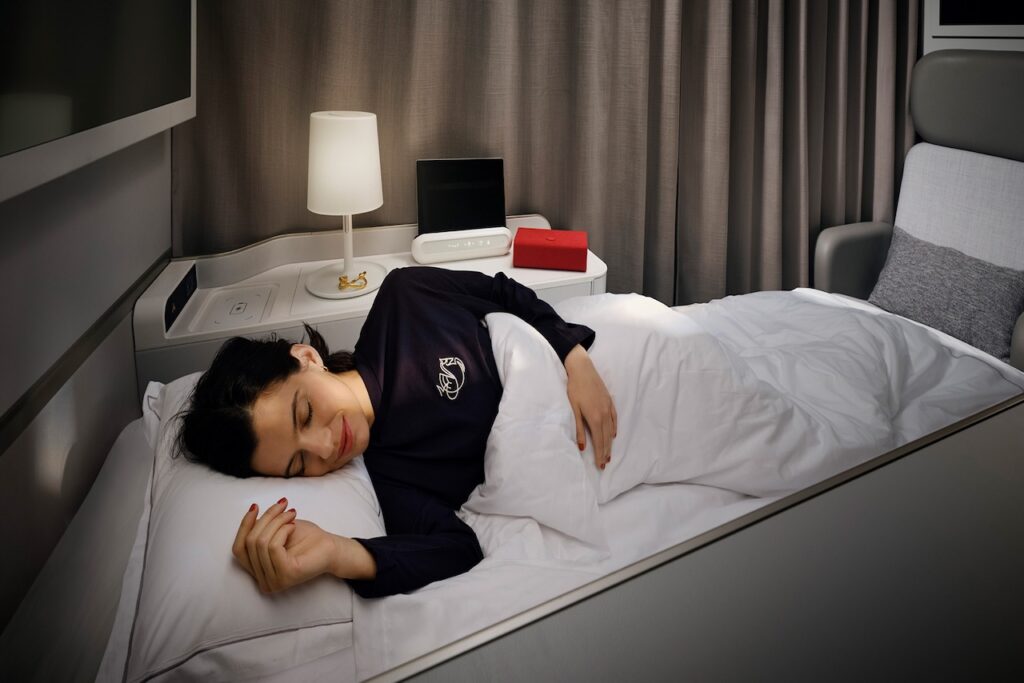 Geschäftsreisen mit Air France und KLM: Eine Frau schläft in der Le Premiere Class von Air France auf einem Bett in ihrer Suite