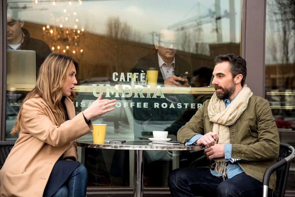 Geschäftsreisen im Schatten des Tourismus: Ein Mann und eine Frau sitzen an einem Tisch in einem Café in Seattle, Washington, USA, Caffe Umbria, Ballard,