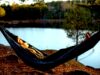 Wo „Introvertierte“ endlich urlauben können Urlaub für Introvertierte: A woman is lying in a hammock by a lake