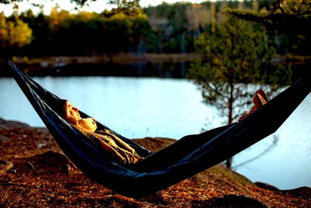 Wo Introvertierte urlaub können Urlaub für Introvertierte: A woman is lying in a hammock by a lake